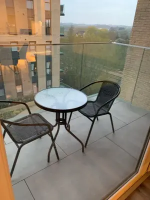 a table and two chairs on a balcony at The Melodies with Free Parking , Harlow in Harlow
