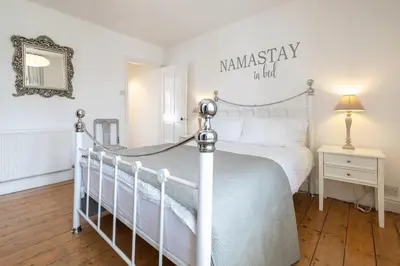 a bedroom with a white bed and a mirror at Charming Kings road in Bury Saint Edmunds