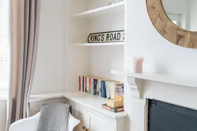 a living room with a fireplace and a shelf with books at Charming Kings road in Bury Saint Edmunds