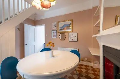 a dining room with a white table and blue chairs at Charming Kings road in Bury Saint Edmunds