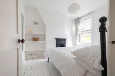 a white bedroom with a bed and a fireplace at Charming Kings road in Bury Saint Edmunds
