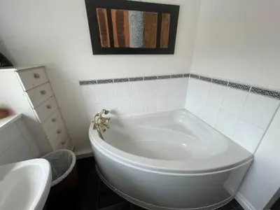 a white bath tub in a bathroom with a sink at Spacious House Near Cambridge - Free Parking and Garden in Cambridge