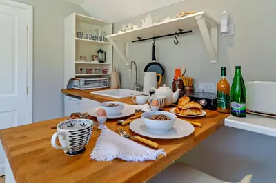 a kitchen with a table with cups and plates of food at 1 Bed in Cratfield oc-t29434 in Cratfield