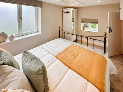 a bedroom with a bed with white sheets at The Church Rooms in Wenhaston