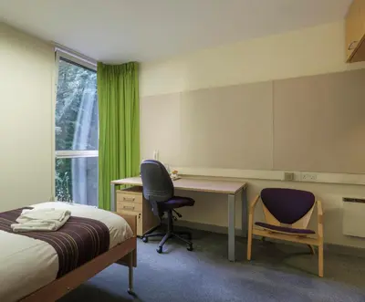 a bedroom with a bed and a desk and chair at Murray Edwards College, Cambridge in Cambridge