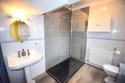 a bathroom with a shower and a sink and a toilet at Mermaid Cottages in Frinton-on-Sea