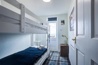 a bedroom with a bunk bed and a staircase at Stunning Cottage in the Heart of Old Leigh - Pass the Keys in Southend-on-Sea