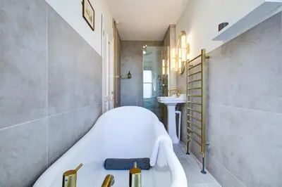 a bathroom with a bath tub and a sink at Stunning Cottage in the Heart of Old Leigh - Pass the Keys in Southend-on-Sea