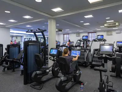 a person sitting on a laptop in a gym at Bedford Lodge Hotel & Spa in Newmarket