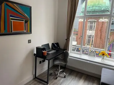 a desk with a laptop computer on it next to a window at Nero view, Southend City High Street in Southend-on-Sea