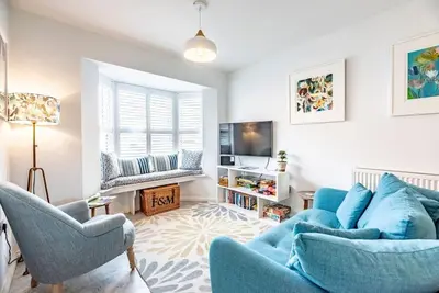 a living room with a blue couch and two chairs at The Salty Dog, Aldeburgh in Aldeburgh