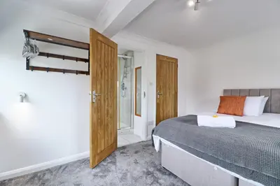 a bedroom with a bed and a sliding glass door at LMV Property - Modern Luxury Family Home in Theydon Bois With London Skyline Views in Theydon Bois