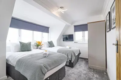 two beds in a room with two windows at LMV Property - Modern Luxury Family Home in Theydon Bois With London Skyline Views in Theydon Bois