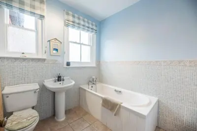 a bathroom with a toilet and a sink and a bath tub at Pebble House, Aldeburgh in Aldeburgh