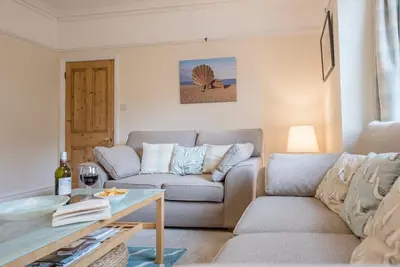 a living room with a couch and a table at Pebble House, Aldeburgh in Aldeburgh