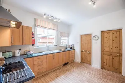 a kitchen with wooden cabinets and a counter top at Pebble House, Aldeburgh in Aldeburgh