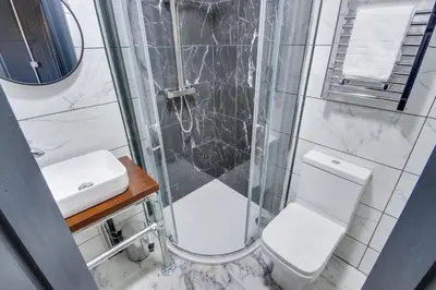 a bathroom with a shower and a toilet and a sink at Studio Apartments in Southend in Southend-on-Sea