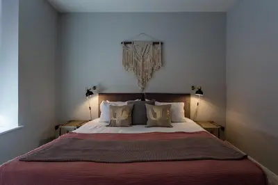a bedroom with a large bed with two lamps at St Johns Apartments & Studios Southend in Southend-on-Sea