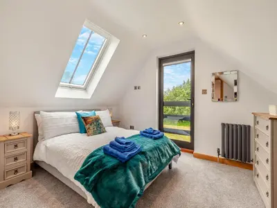 a bedroom with a bed and a window at Gladwyns Farm Lodge in Thaxted