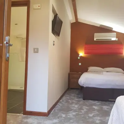 a hotel room with a bed and a television at Heritage Grange at Thurston, Hotel in Bury Saint Edmunds