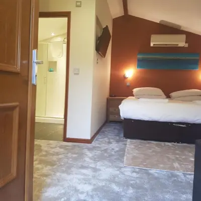 a hotel room with two beds and a bathroom at Heritage Grange at Thurston, Hotel in Bury Saint Edmunds