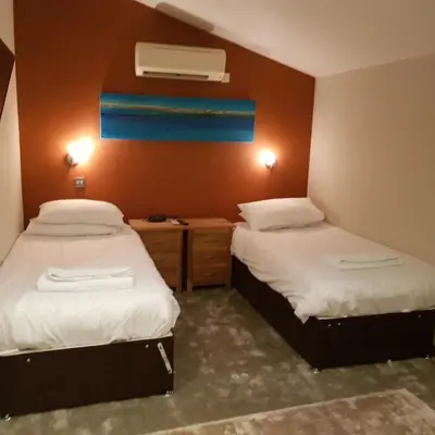 a bedroom with two beds and a window with aperature at Heritage Grange at Thurston, Hotel in Bury Saint Edmunds