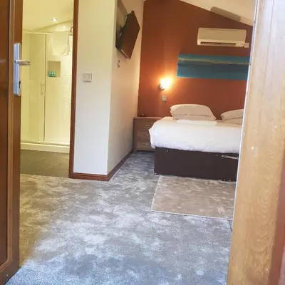 a hotel room with a bed and a bathroom at Heritage Grange at Thurston, Hotel in Bury Saint Edmunds