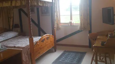 a bedroom with a canopy bed and a window at Six Bells Inn in Bardwell