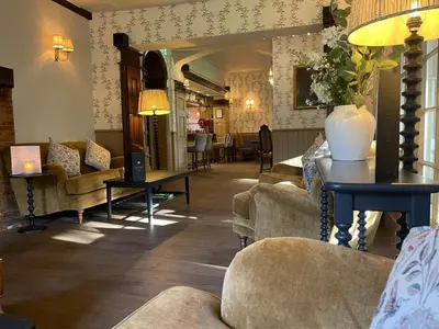 a living room with couches and chairs and a table at Ravenwood Hall Hotel in Bury Saint Edmunds