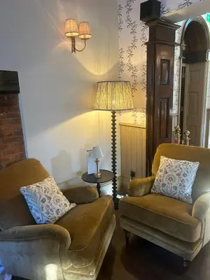 a living room with two couches and a lamp at Ravenwood Hall Hotel in Bury Saint Edmunds