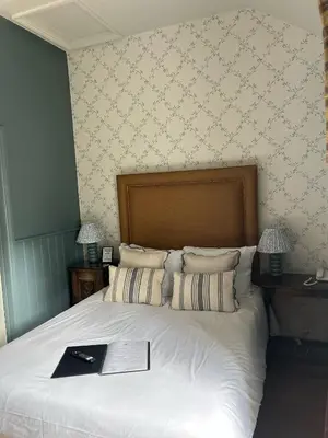 a bedroom with a bed with a book on it at Ravenwood Hall Hotel in Bury Saint Edmunds