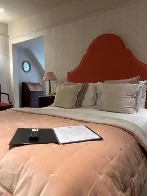a bed with a tray with a book on it at Ravenwood Hall Hotel in Bury Saint Edmunds