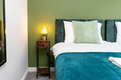 a bedroom with a bed and a lamp on a night stand at Entire House - Contractor's, Families & More in Little Wymondley