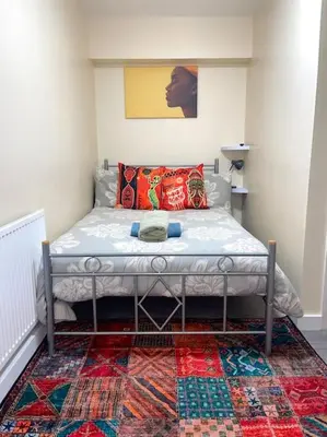 a small bedroom with a bed with a rug at 12 Penn Gardens Standard Room- 4 in Friern Barnet