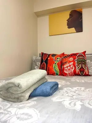 a bed with a blanket and pillows on it at 12 Penn Gardens Standard Room- 4 in Friern Barnet