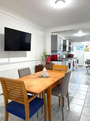 a kitchen with a wooden dining table and chairs at 12 Penn Gardens Standard Room- 4 in Friern Barnet