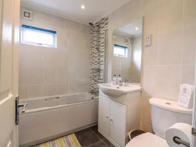 a bathroom with a sink and a toilet and a tub at Owls Retreat, Lodge 11 in Aldeburgh
