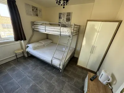 a room with two bunk beds and a refrigerator at Clacton Guest House in Clacton-on-Sea