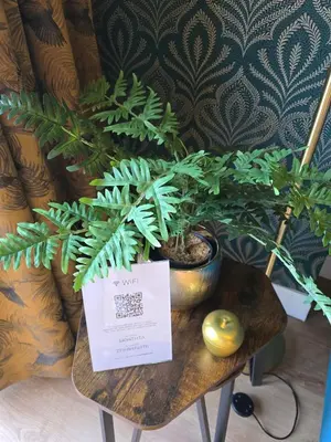 a table with a potted plant and a sign on it at Munnings Lodge Apartment in Mendham