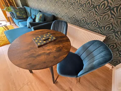 a wooden table with two chairs and a table and a couch at Munnings Lodge Apartment in Mendham