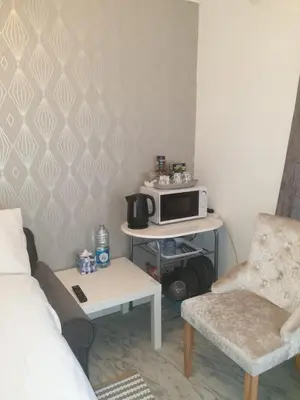 a small living room with a microwave and a couch at Room Stay - Marks tey, Colchester, United Kingdom in Marks Tey