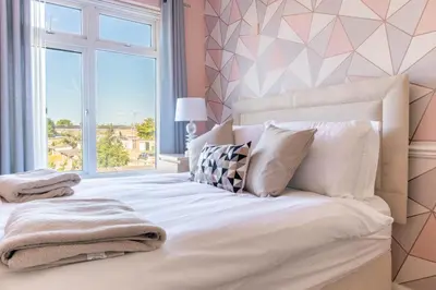 a bedroom with a large white bed with a window at 5 bedroom with Prking in Laindon