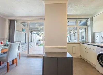a kitchen with a washer and dryer and a dining room at 5 bedroom with Prking in Laindon