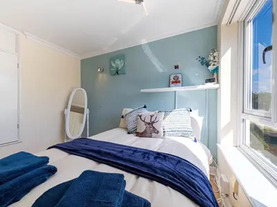 a small bedroom with a bed and a window at 5 bedroom with Prking in Laindon