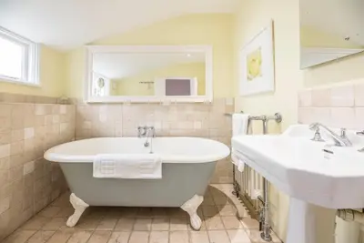 a bathroom with two sinks and a bath tub at Oriel Cottage, Aldeburgh in Aldeburgh