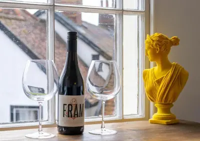 a bottle of wine and two glasses on a table at The Keep - Framlingham in Framlingham