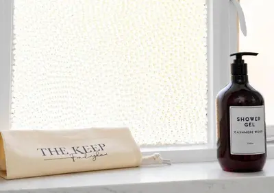 a bottle of wine sitting on a window sill next to a bag at The Keep - Framlingham in Framlingham