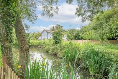 a garden with a pond in front of a house at Little Swattesfield, Eye in Eye