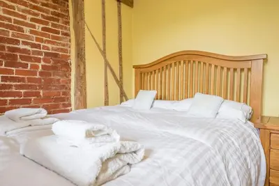 a white bed with towels on top of it at Little Swattesfield, Eye in Eye