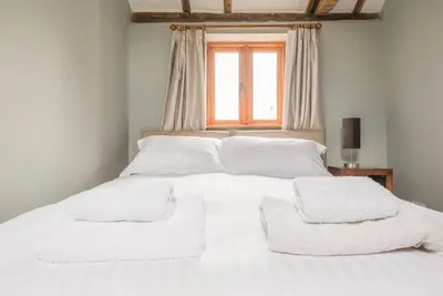 a white bed with white sheets and towels on it at Little Swattesfield, Eye in Eye